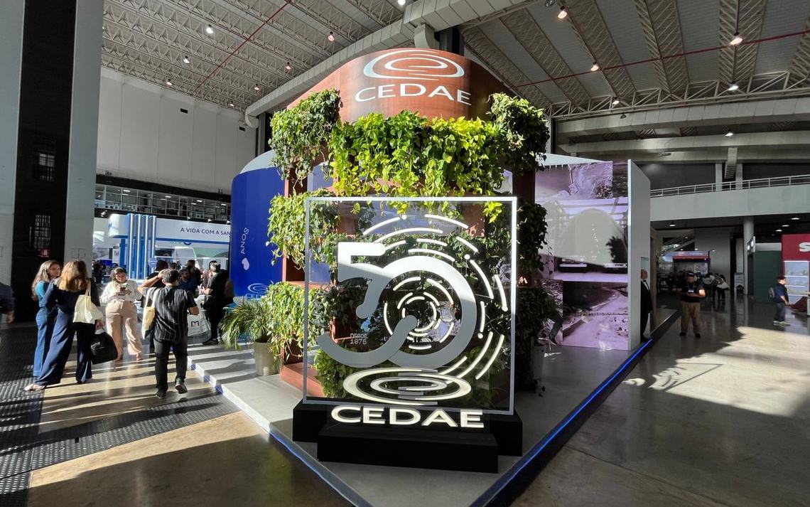 Estande CEDAE na FITABES 2025 visto da feira, com fachada curva em LED e totem dos 50 anos
